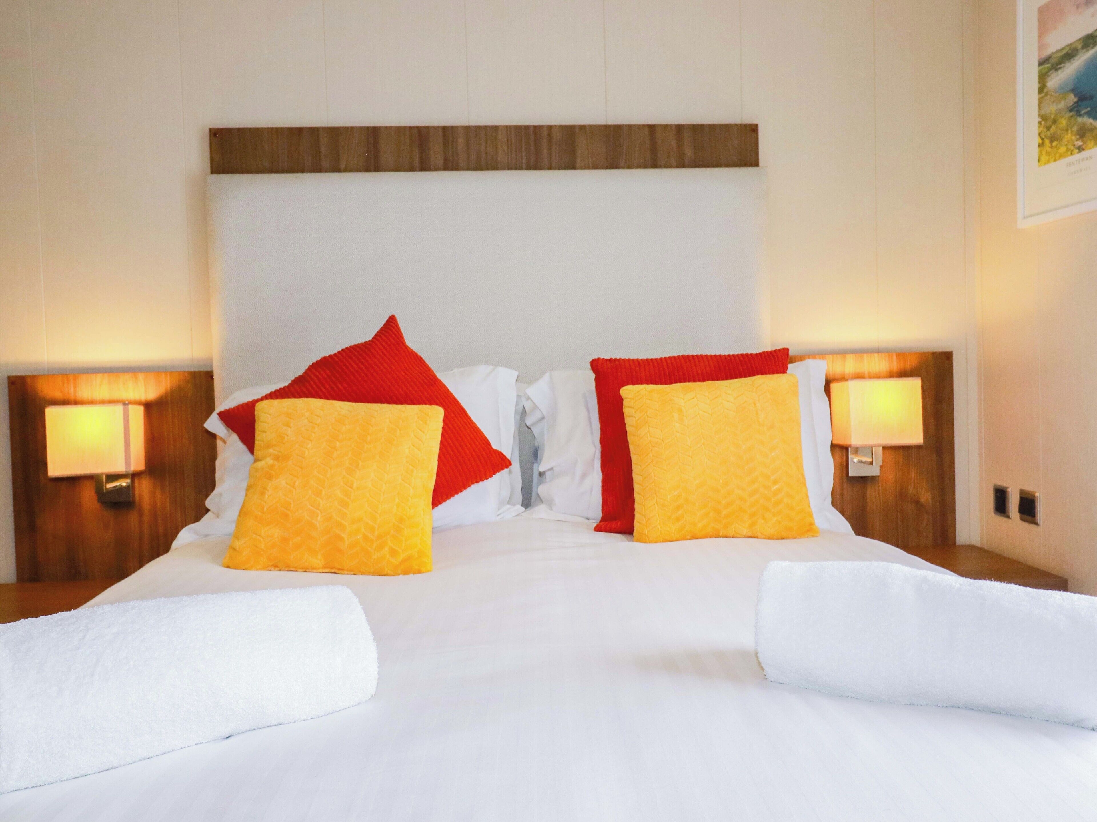 A hotel room with a large bed, two nightstands, and a wooden headboard.