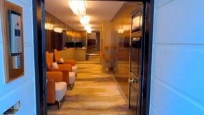 Entrada de hotel con un suelo alfombrado que dice "HERTFORD COURT", que conduce a un pasillo bien iluminado con zonas de estar.