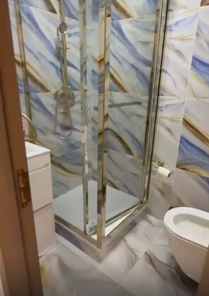 Ein Badezimmer mit Duschkabine, Toilette und Waschbecken.