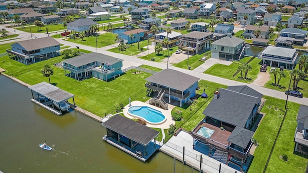 A residential area with houses, a swimming pool, and a dock. - Purple Pelican Paradise by Ryson Vacation Rentals (Galveston)
