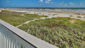 A beach with a wooden walkway and grassy dunes. - Casablanca by Ryson Vacation Rentals (Galveston)