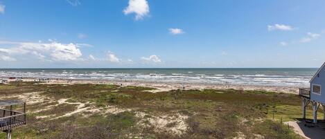 Une vue sur la plage avec une maison et un sentier menant à la plage.