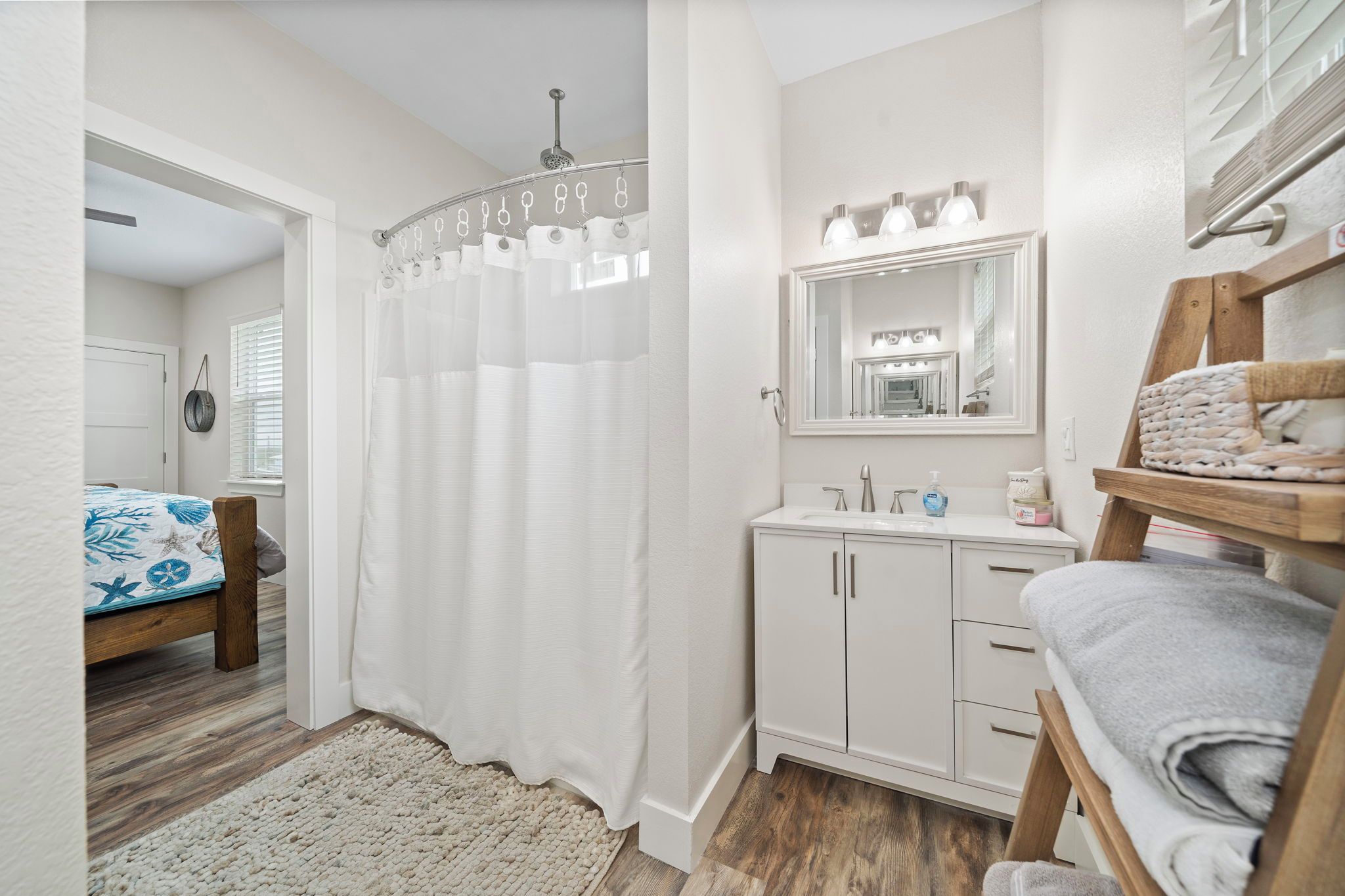 Une chambre à coucher avec un lit en bois, une table de chevet blanche, une armoire blanche et un rideau de douche.