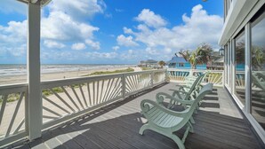 A wooden deck with chairs overlooking a beach. - Ocean View by Ryson Vacation Rentals (Galveston)