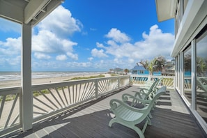A wooden deck with chairs overlooking a beach. - Ocean View by Ryson Vacation Rentals (Galveston)