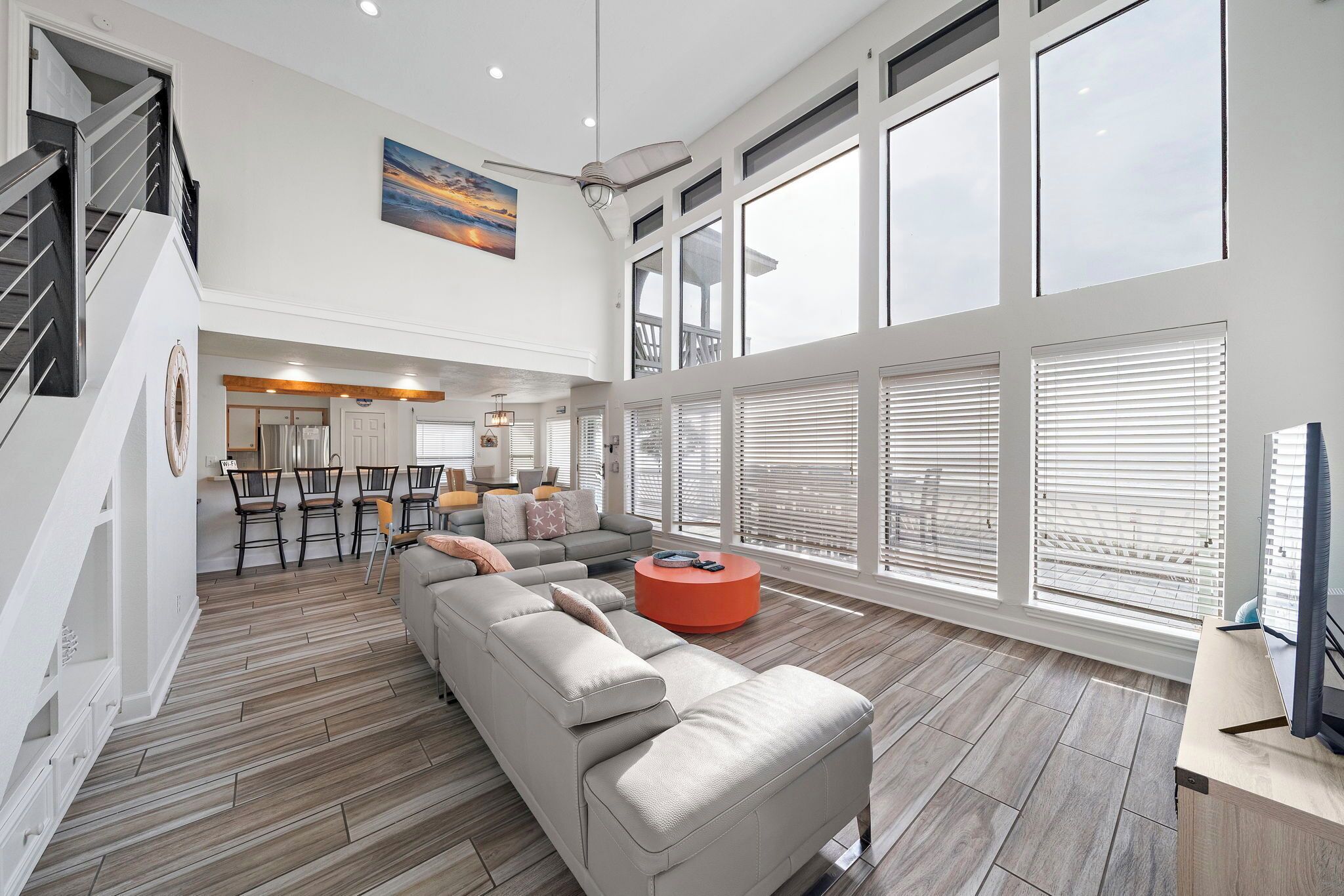 A spacious living area with a large sofa, a round coffee table, and a dining area with chairs.