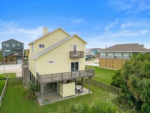 A two-story house with a balcony and a covered porch. - The Krusty Krab by Ryson Vacation Rentals (Galveston)