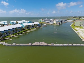 A marina with docked boats, a pier, and a row of blue buildings with balconies.
