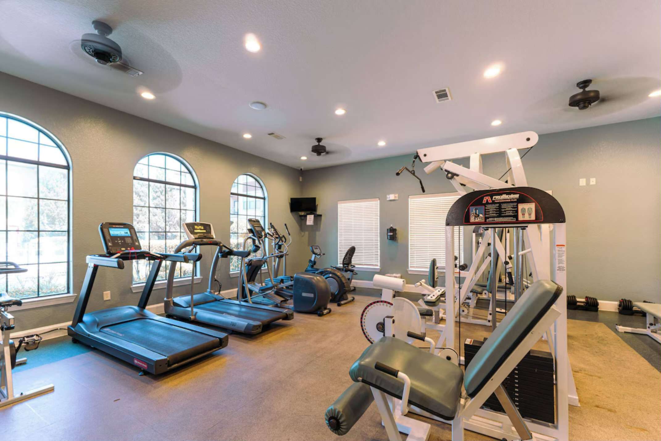 A gym with treadmills, elliptical machines, and weight equipment.
