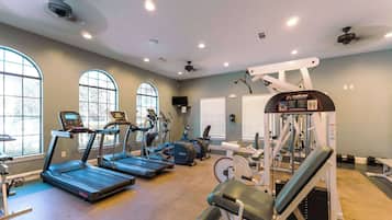 A gym with treadmills, elliptical machines, and weight equipment.