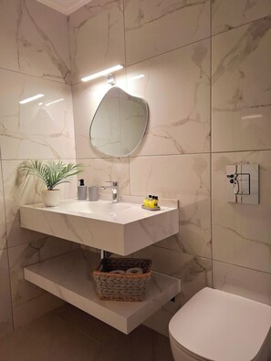 Familie appartement | Badkamer | Een haardroger, pantoffels, handdoeken, zeep