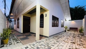 A building with a tiled entrance area, a bench, and potted plants. - Dream villa and homestay madiha Home (Madiha)