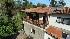 A two-story building with a balcony, a stone facade, and a tiled roof. - Rea Villa, Vourvourou (Vourvourou)