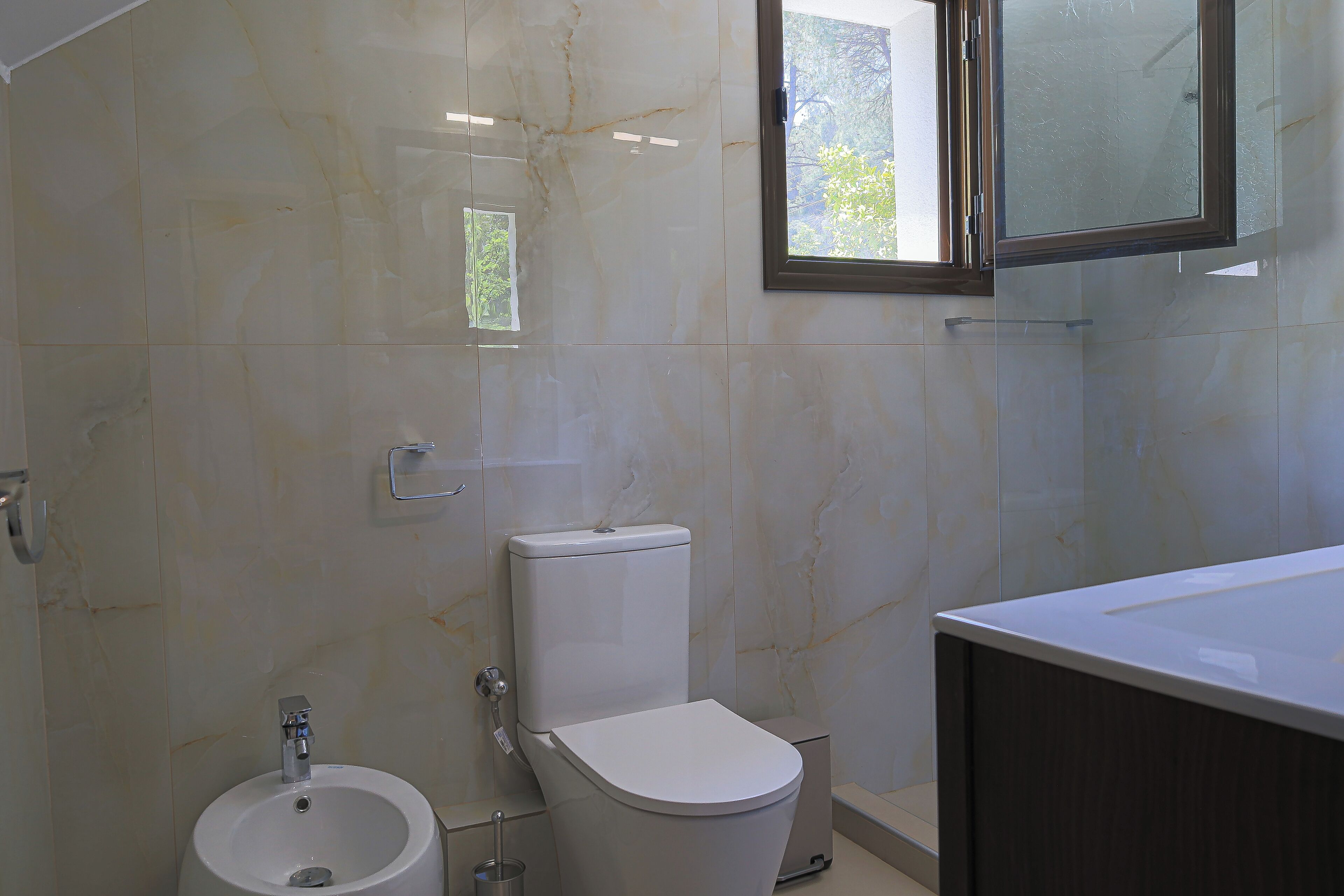 A bathroom with a toilet, bidet, and sink.