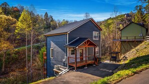 A cabin with a porch, a deck, and a small outdoor area.