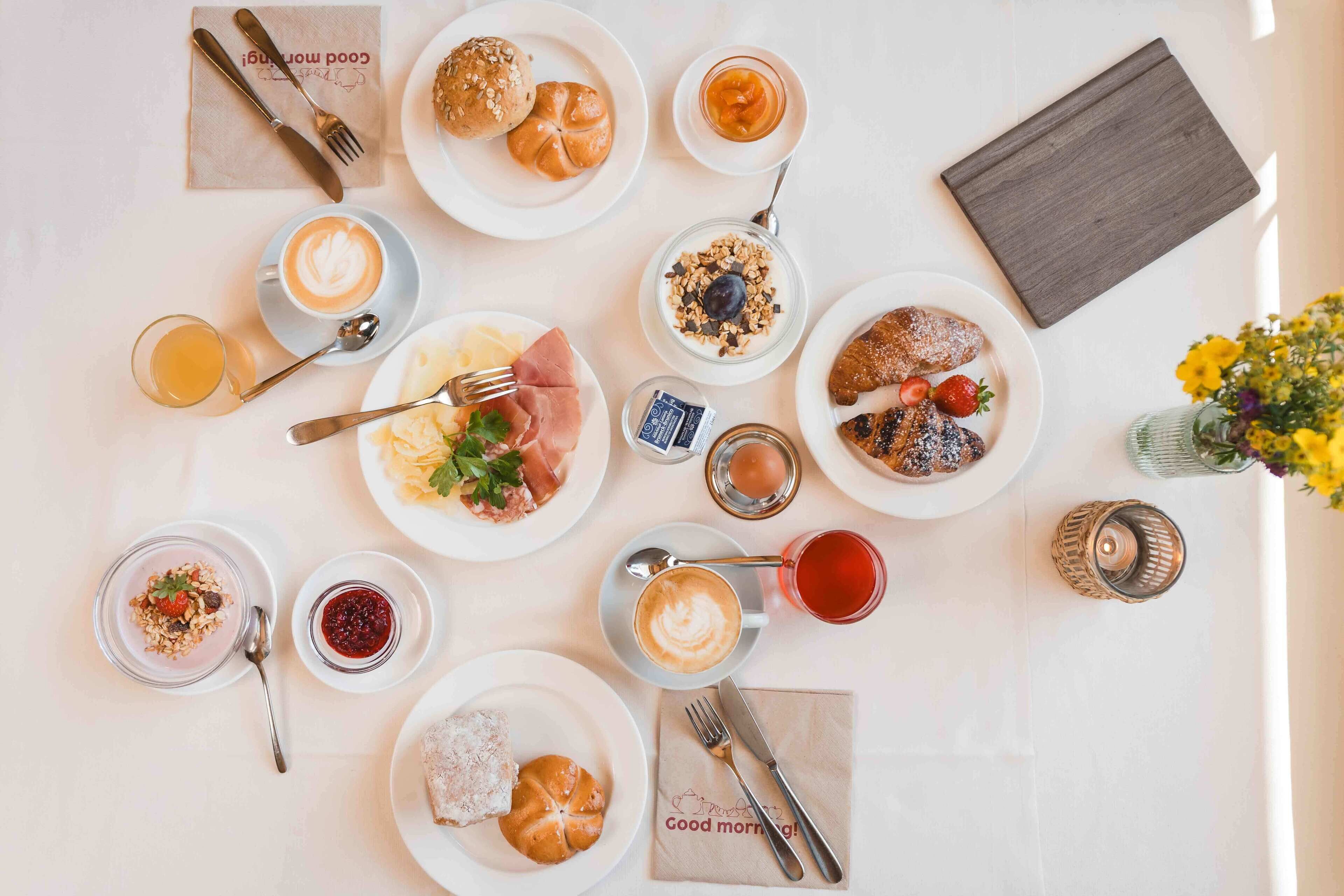 Un buffet de petit-déjeuner avec divers plats et boissons disposés sur une table.
