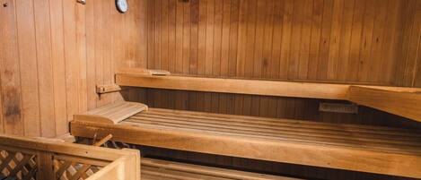 A sauna with wooden benches and a clock on the wall.