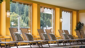 A poolside area with lounge chairs and a clear view of the outdoors. - Smart Hotel Firn (Senales)