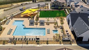 An aerial view of a residential area with a large swimming pool, sun loungers, and a tennis court. - Charming townhome with WiFi, AC, Pool and Community Center in Peaceful Fallbrook (Fallbrook)