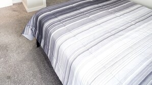 Ein Schlafzimmer mit Bett, Kleiderschrank und Tür.