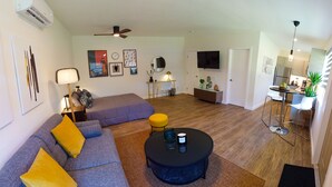 Un salon moderne comprenant un canapé, une table basse et un coin repas avec une table et des chaises.