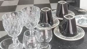 A kitchen counter with various glassware and plates, a checkered floor, and a decorative wall piece. - Charming 3 bedroom house COP (Umarizal Belém)