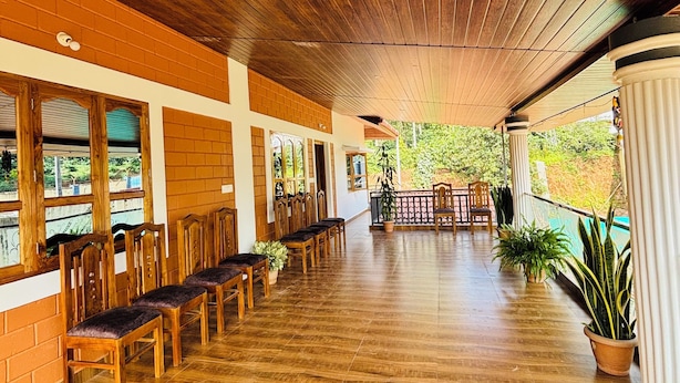 A covered outdoor seating area with wooden benches and potted plants.