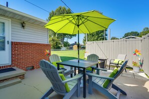A patio with a table and chairs, an umbrella, and a fenced yard. - Charming Kingsport Home w/ Spacious Fenced Yard! (Kingsport)