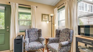 A room with two patterned armchairs, a small round table, a floor lamp, a television, and a cabinet. - < 1/2 Mi to OSU: Studio in Corvallis Near Parks (Corvallis)