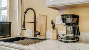 A kitchen with a modern coffee maker, a sink with a faucet, and a window with curtains. - < 1/2 Mi to OSU: Studio in Corvallis Near Parks (Corvallis)