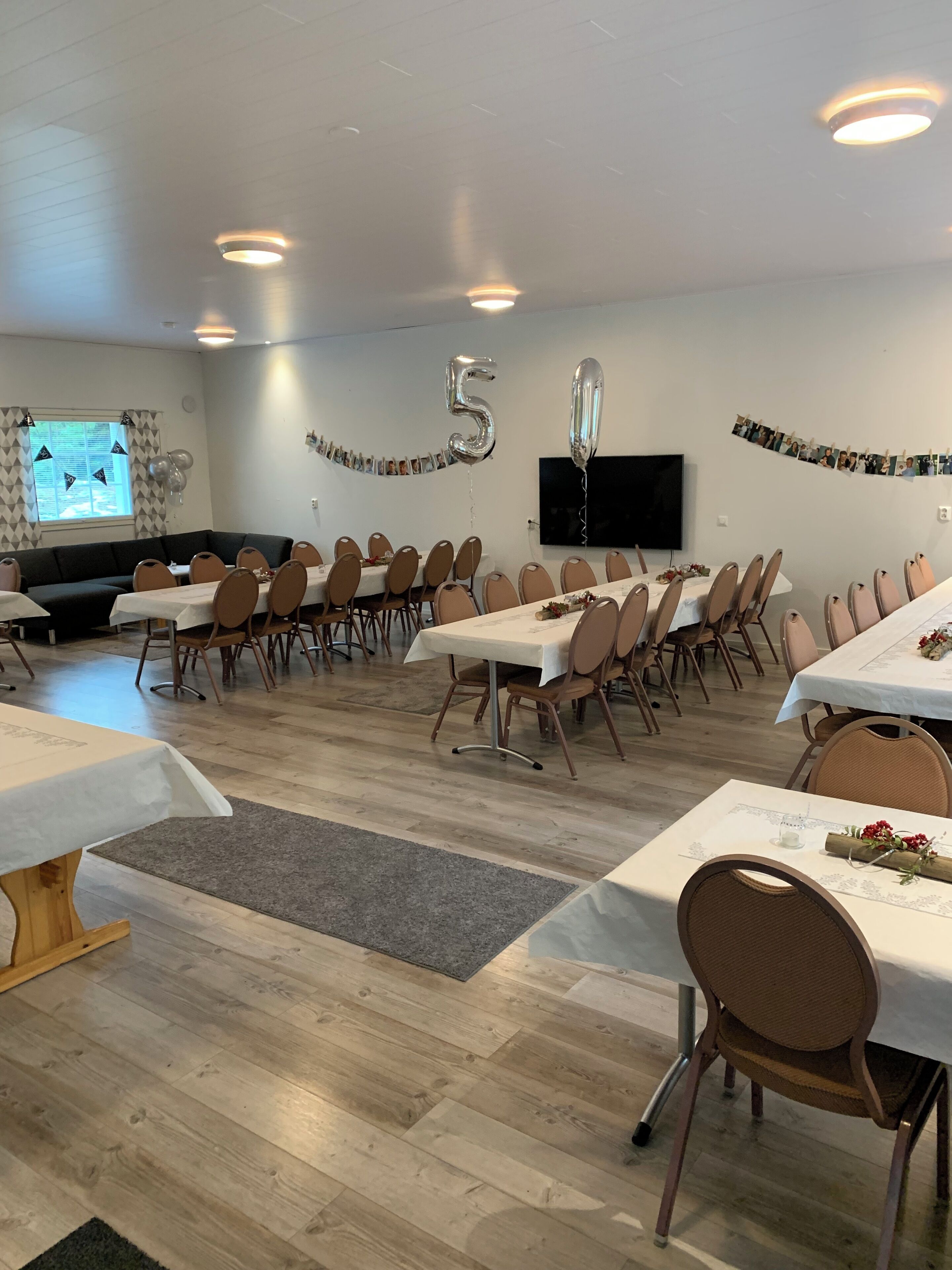 Une salle de conférence équipée de plusieurs tables et chaises, d’un grand écran et d’une banderole portant le chiffre 5.