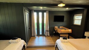Habitación de hotel con dos camas, una mesa de fútbol de mesa, un televisor y vistas al exterior.