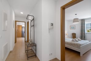 A bedroom with a bed, bedside table, lamp, and a window with curtains. - Vrbo Property (Unknown)