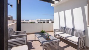A balcony with wooden furniture, a small table, and a potted plant.