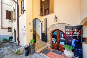 A building entrance with a staircase, a door, and a poster for DeeJay School. - Vrbo Property (Foligno)