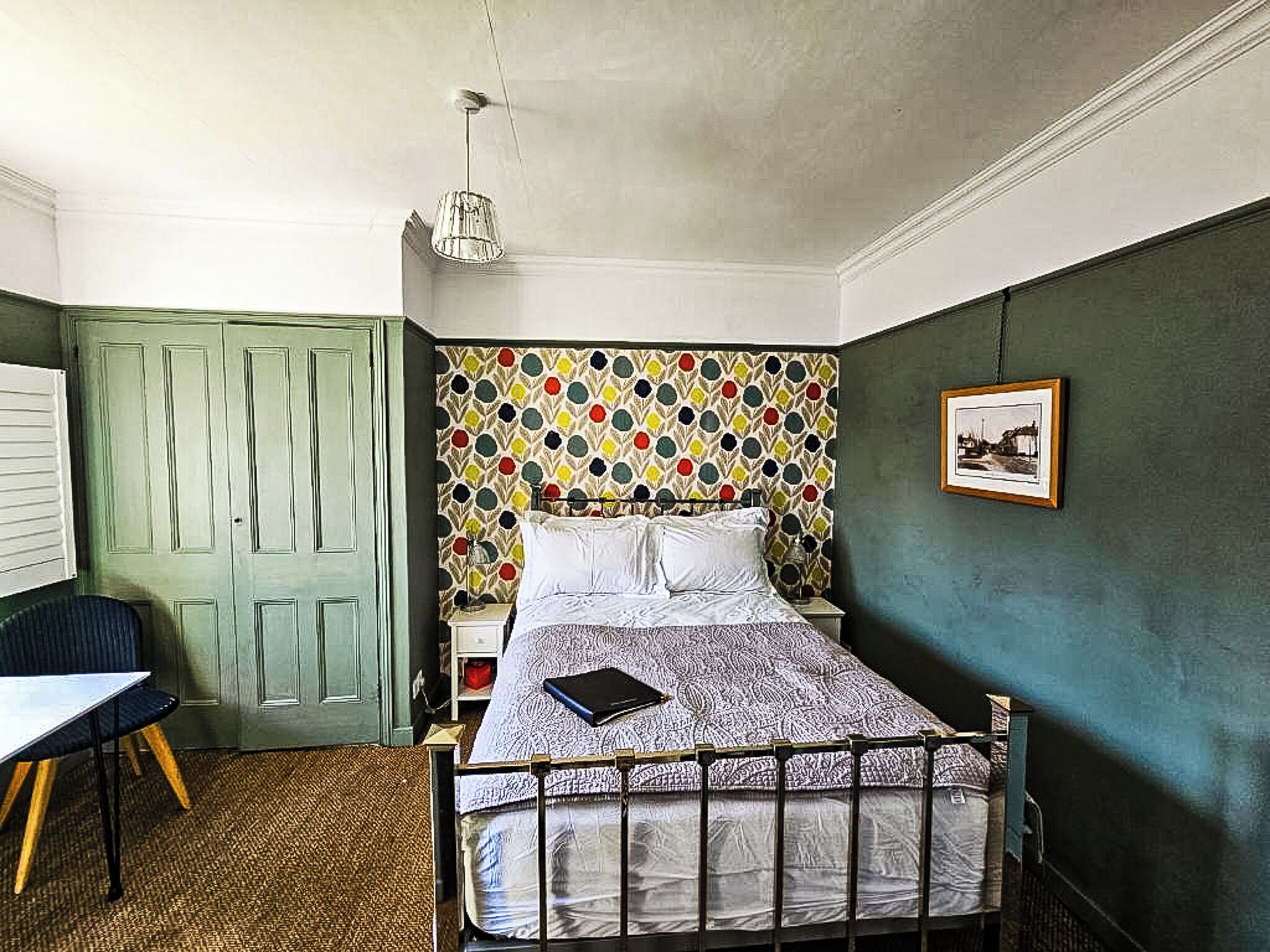 A bedroom with a bed, a desk, and a chair.