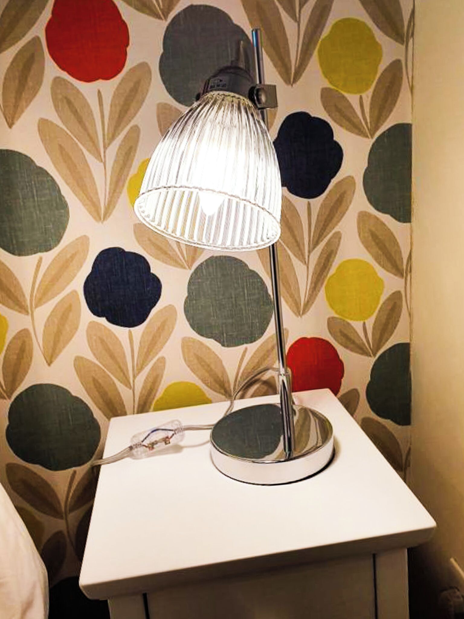 A bedside table with a lamp and a power strip.