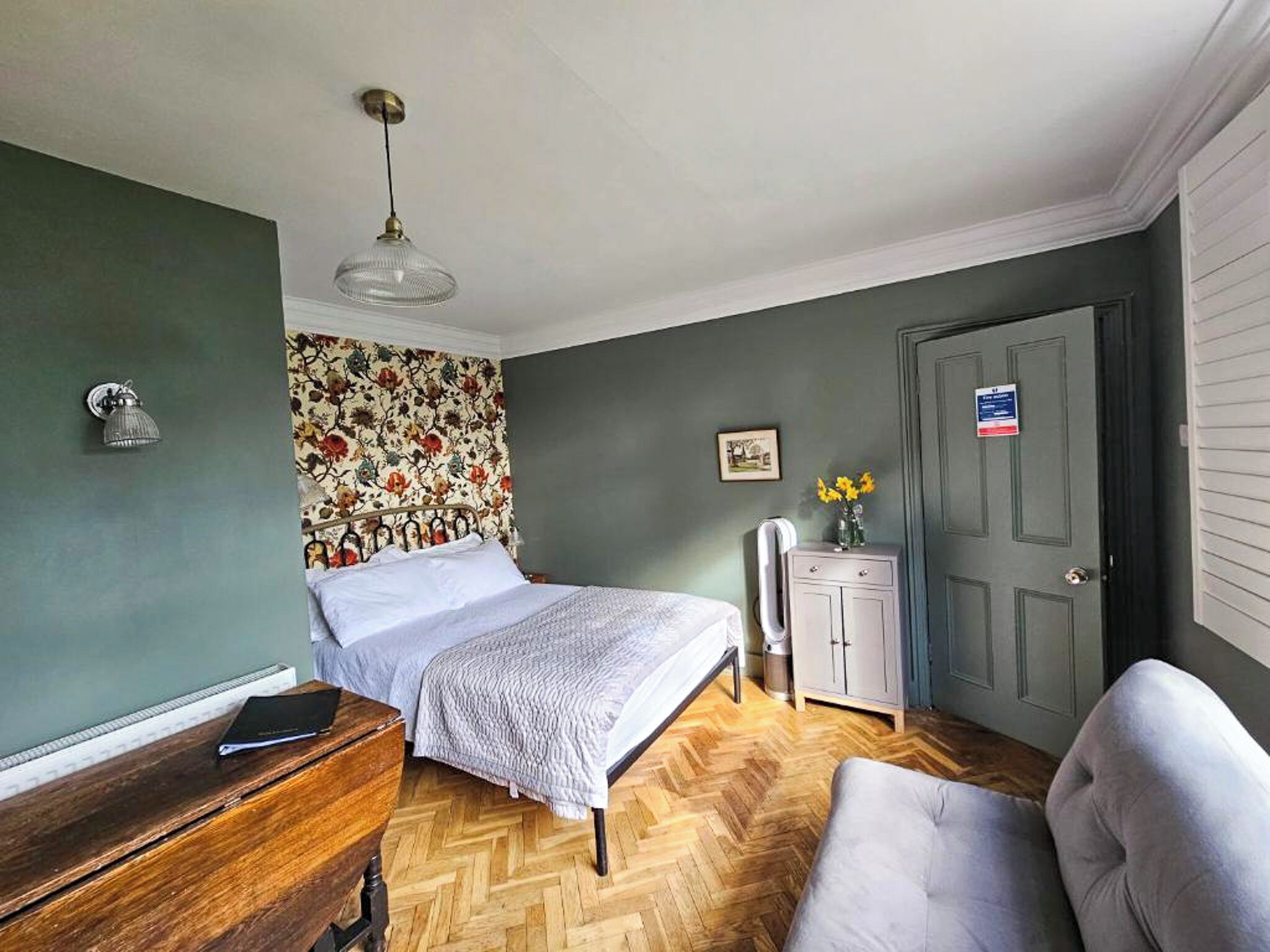 A bedroom with a bed, dresser, and a cabinet.