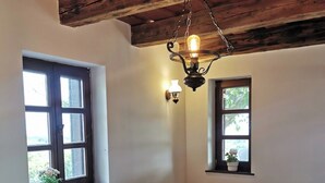 A cozy living room with a sectional sofa, a wooden coffee table, and a hanging light fixture. - Villa a Balaton-Felvidéken, ahol jakuzziban gyönyörködhet a tó panorámájában (Vászoly)