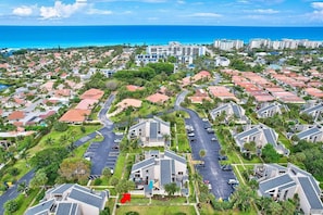 Un quartiere residenziale con case, un parcheggio e un grande albergo sullo sfondo.