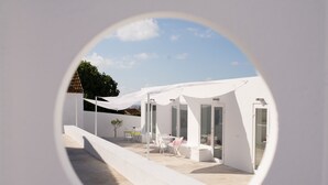 A modern outdoor patio with white furniture and a glass door entrance. - ST Apart 01 in Atouguia da Baleia (Peniche)