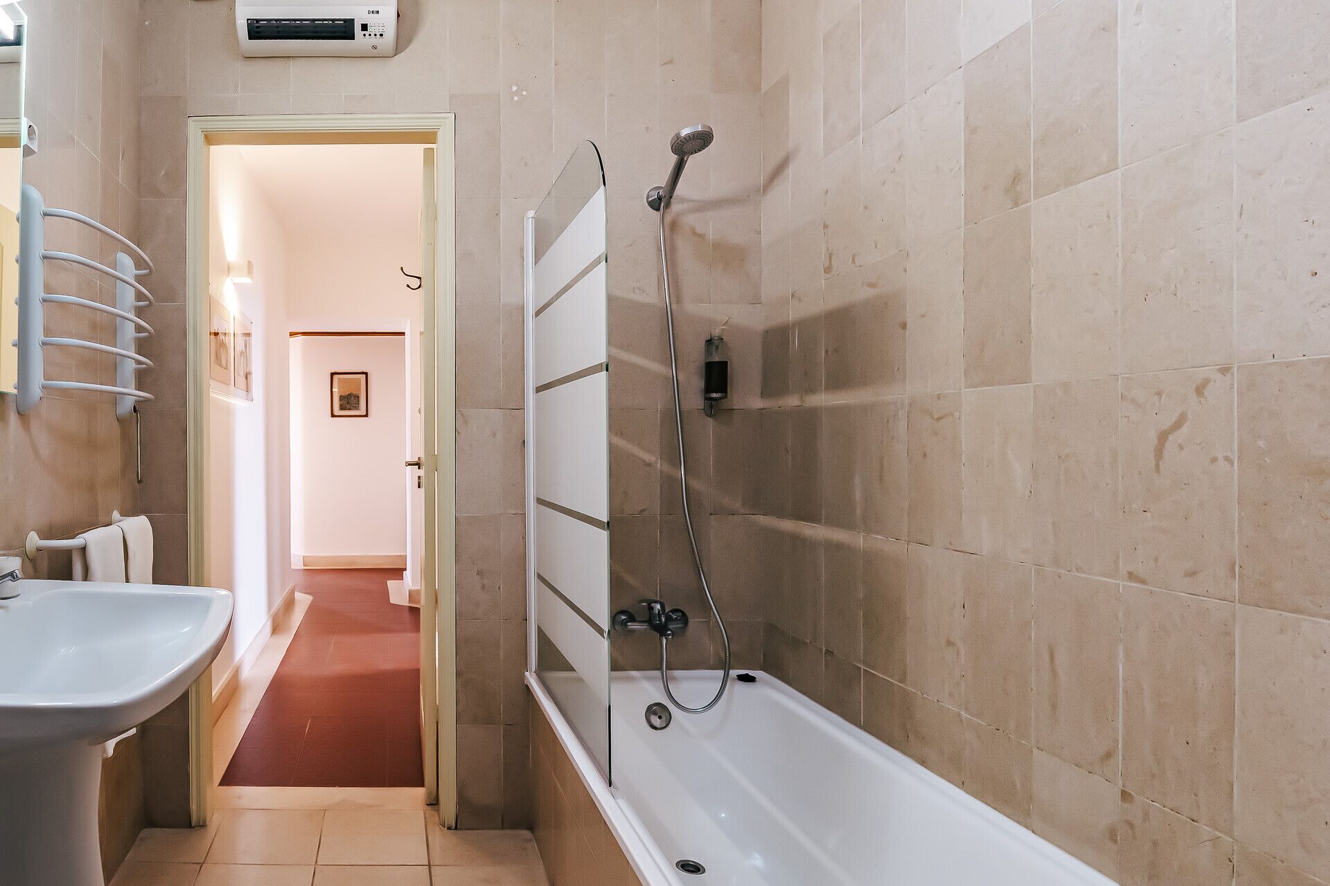 Een badkamer met een bad, douche en wastafel.