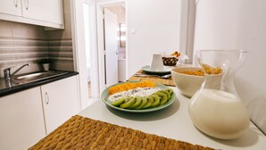 A kitchen with a sink, a plate of fruit, and a glass pitcher of milk on the counter. - Mar Alta - Baleal in Peniche (Peniche)