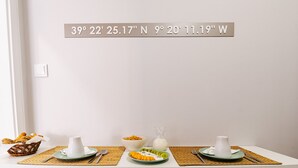 A dining table with a placemat, a bowl of cereal, a glass of milk, and a plate with sliced fruit. - Mar Alta - Baleal in Peniche (Peniche)