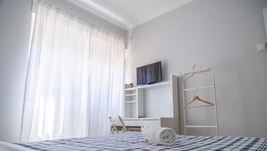 A hotel room with a bed, a desk, a television, and a wardrobe. - Mar Alta - Gamb a (Peniche)