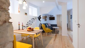 A modern living space with a dining area, a sofa, and a TV.