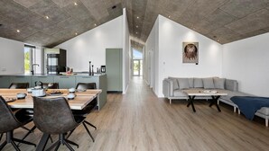 A modern kitchen with a dining area, a sofa, and a painting on the wall. - Stunning home in Sæby with sauna (Sæby)