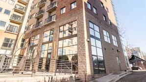 A multi-story residential building with a modern architectural design, featuring large windows and balconies. - Downtown Dream: 2-Bed Condo with Pool & Parking! (Charlotte)