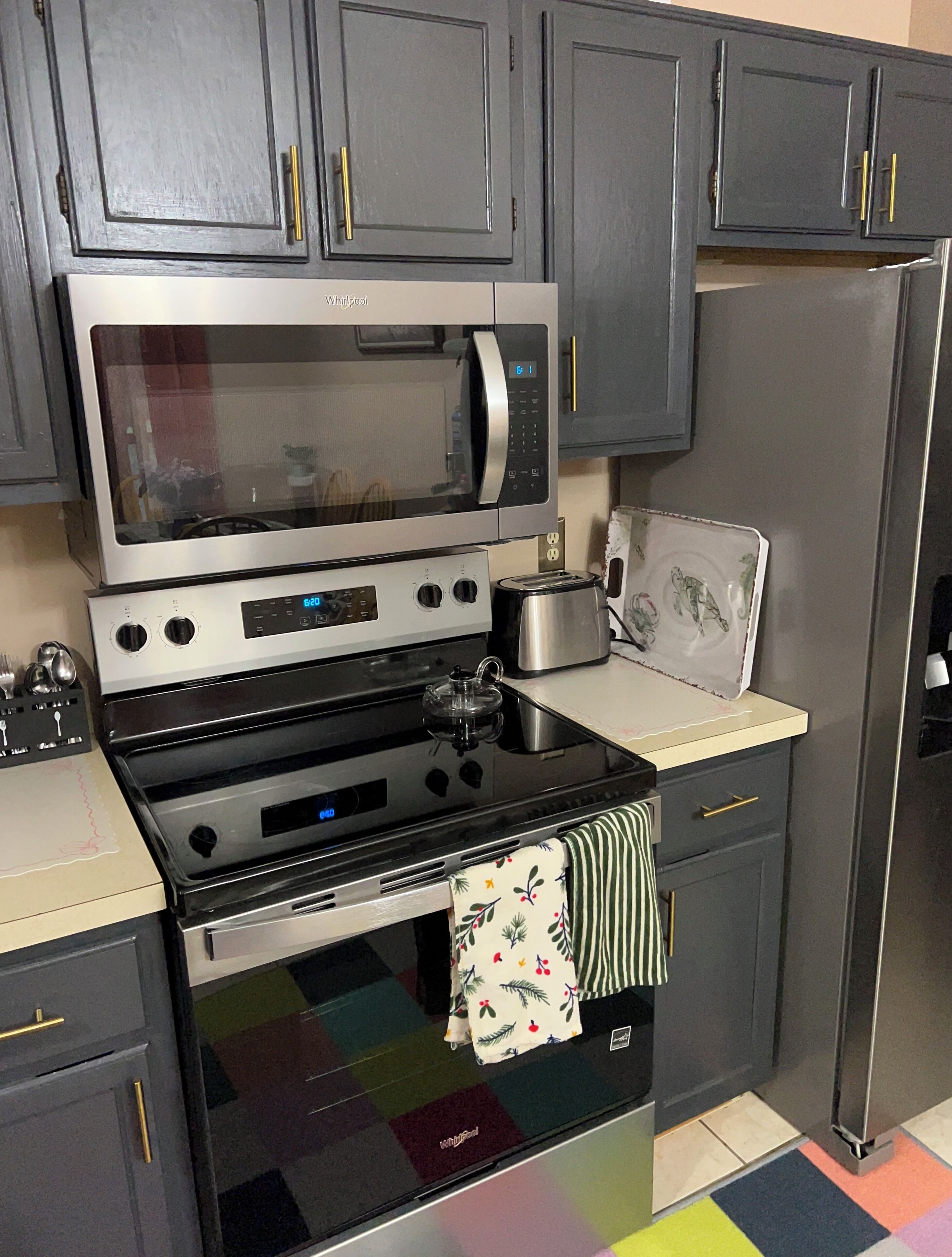 A kitchen with a stainless steel microwave, oven, and toaster.