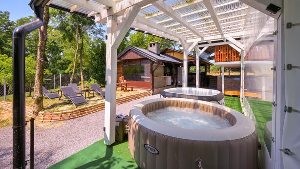 A covered outdoor area with a hot tub, lounge chairs, and a wooden deck. - Pet friendly home in Bjelovar with sauna (Curlovac)